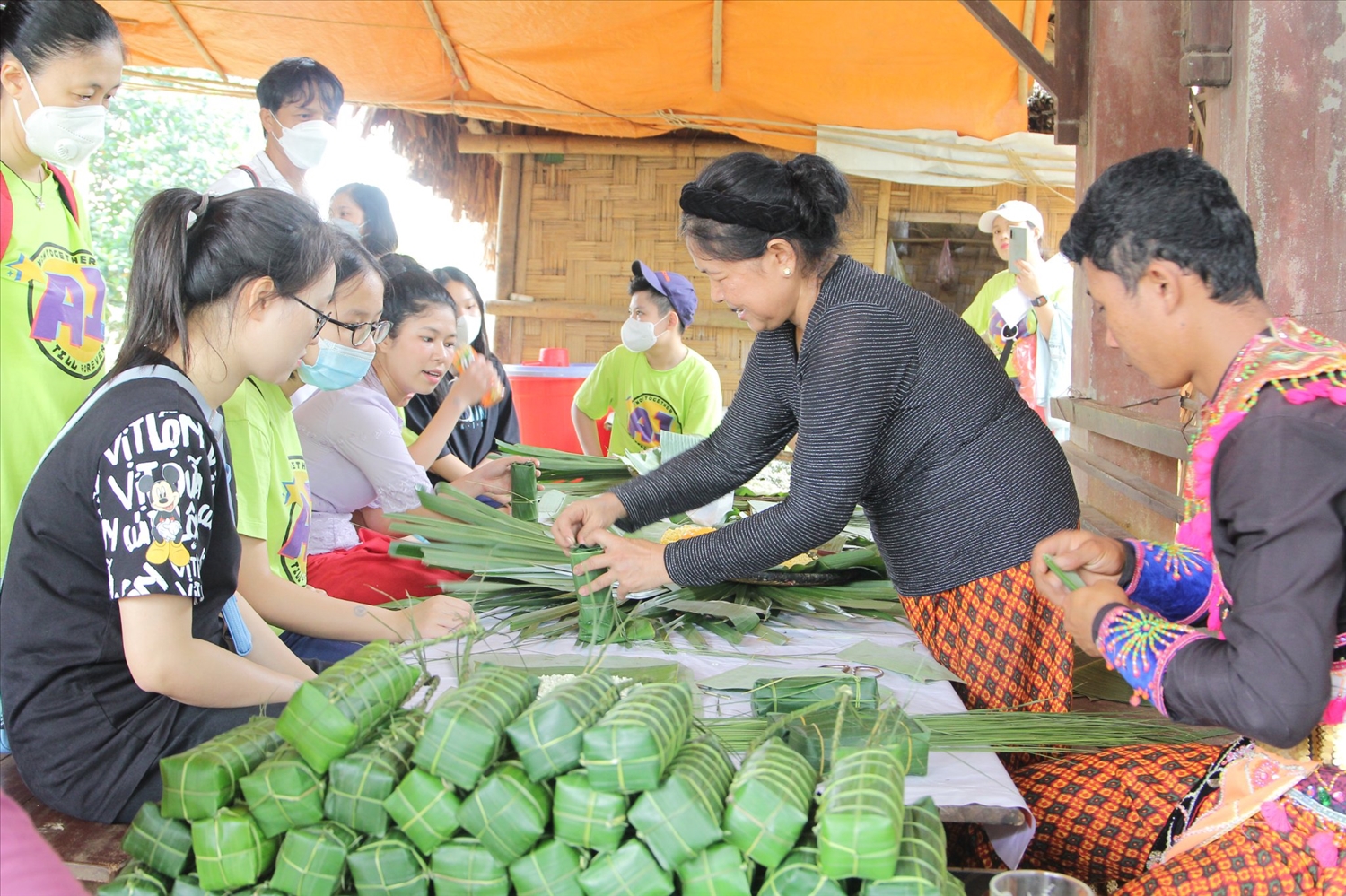 Đồng bào Khmer hướng dẫn du khách cách gói bánh tét 