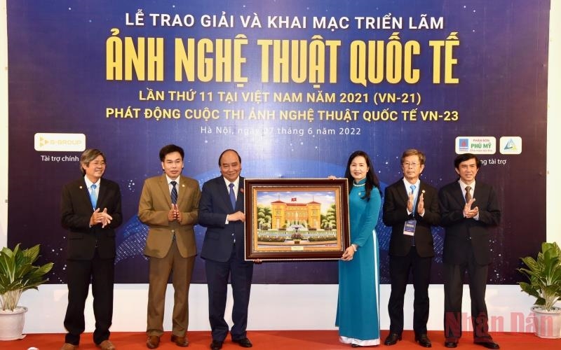 Chủ tịch nước Nguyễn Xuân Phúc tặng quà lưu niệm cho Hội Nghệ sĩ nhiếp ảnh Việt Nam. (Ảnh: Trần Hải) 