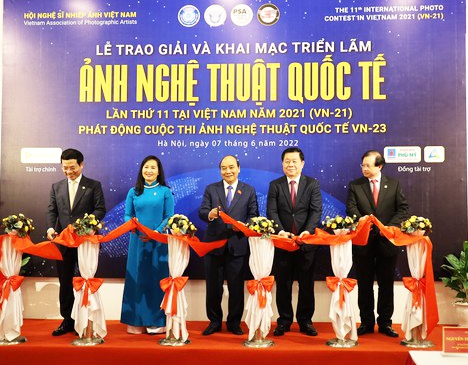 Chủ tịch nước Nguyễn Xuân Phúc cùng Trưởng Ban Tuyên giáo Trung ương Nguyễn Trọng Nghĩa cắt băng khai mạc triển lãm. Ảnh: QUỐC HÙNG