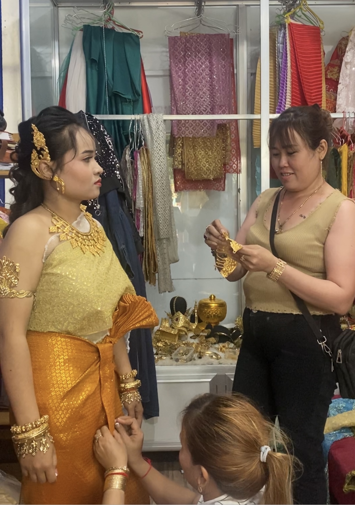 Chị Thạch Sari sửa soạn trang phục truyền thống cho khách tại tiệm đồ trong khuôn viên chùa Bôtum Vong Sa Som Rong