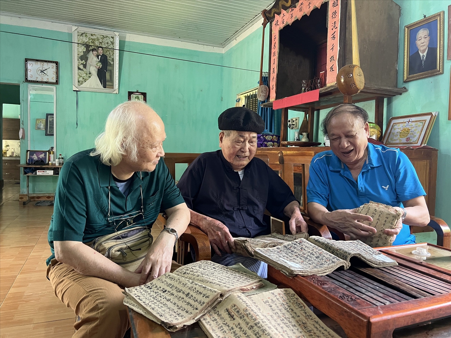 Nghệ nhân Lương Long Vân (giữa) và các nhà nghiên cứu văn hóa dân gian trao đổi về sách cổ