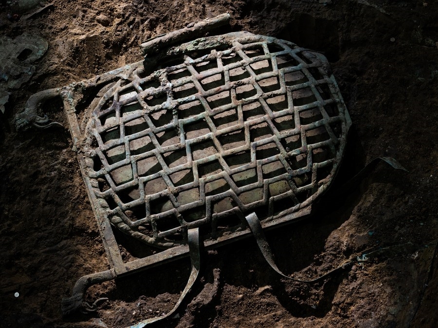 Chiếc hộp đồng chứa một miếng ngọc thạch màu xanh lá cây được khai quật tại di tích Tam Tinh Đôi (Ảnh: Xinhua)