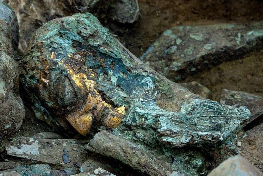 Một chiếc đầu bằng đồng đeo mặt nạ vàng được khai quật trong hố hiến tế số 8 (Ảnh: Xinhua)