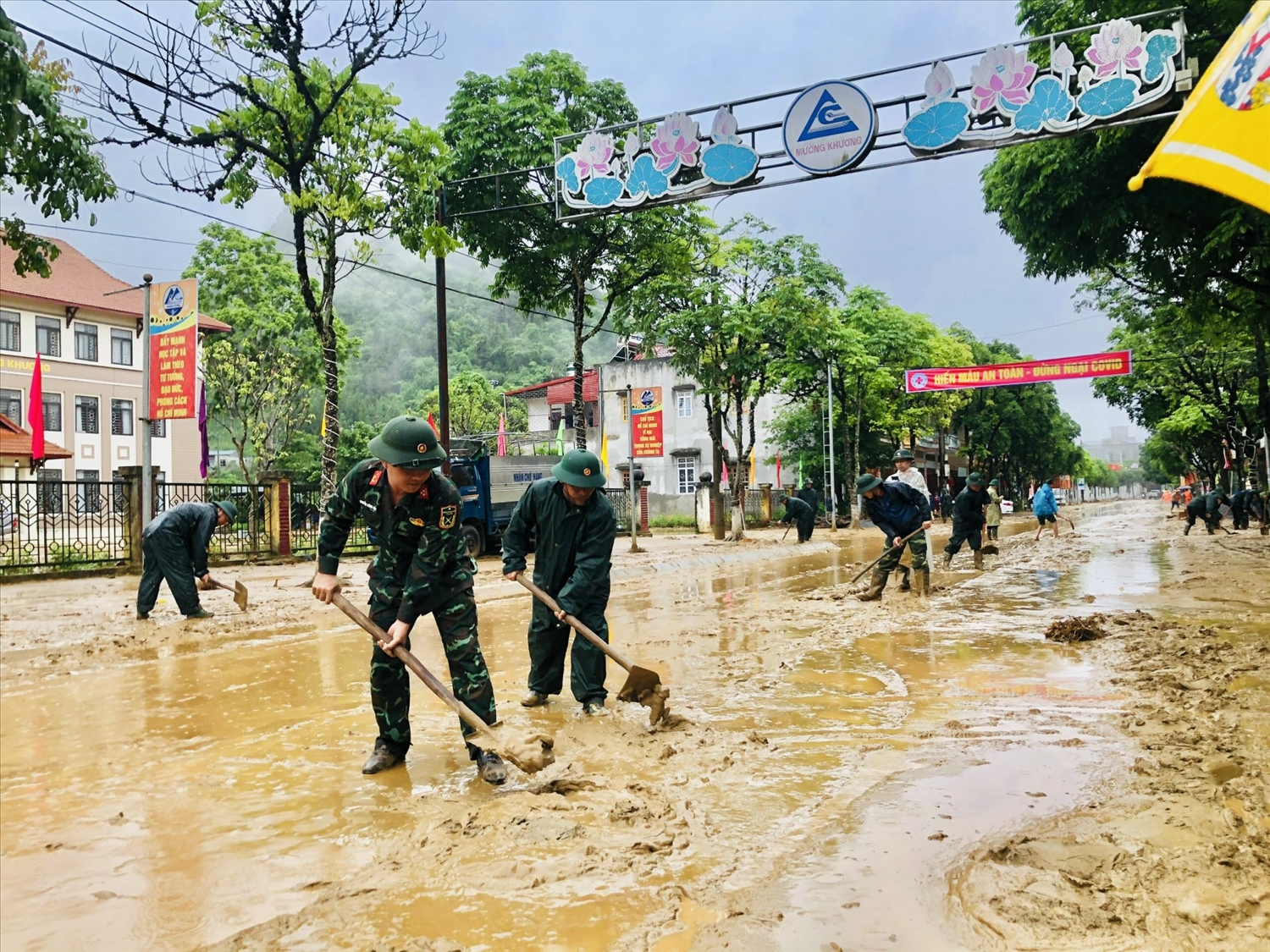 Lực lượng quân đội giúp dân vét bùn, nước, khơi thông dòng chảy, vệ sinh đường phố