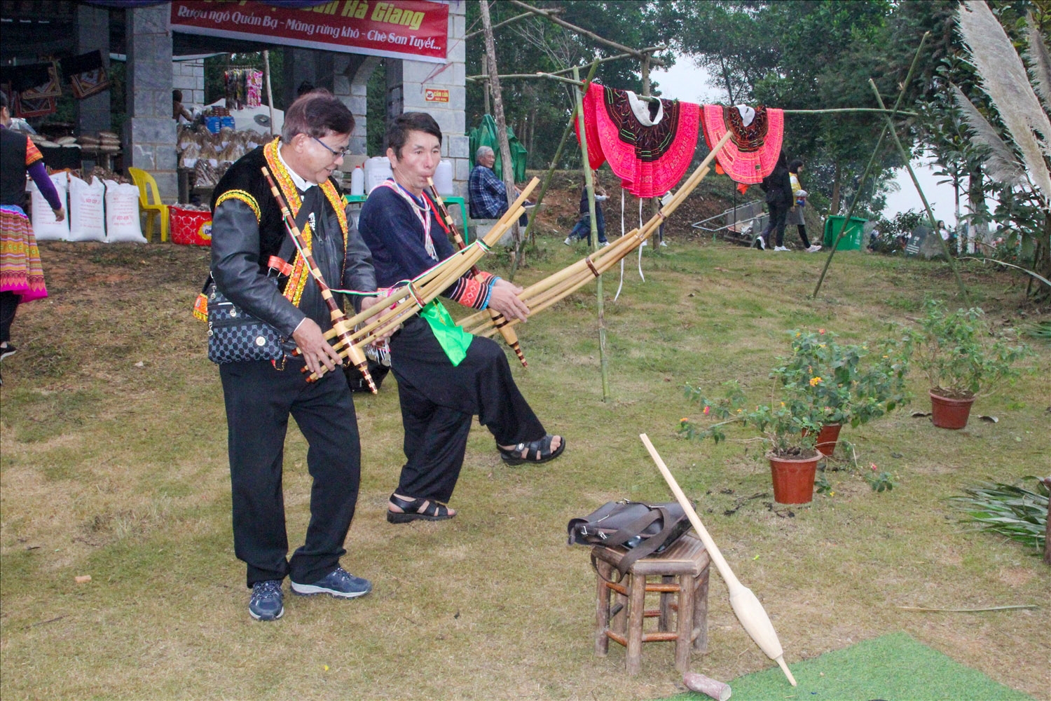 Ông Lý A Lệnh (bên phải) hướng dẫn du khách biểu diễn khèn Mông tại Làng Văn hoá du lịch các dân tộc Việt Nam