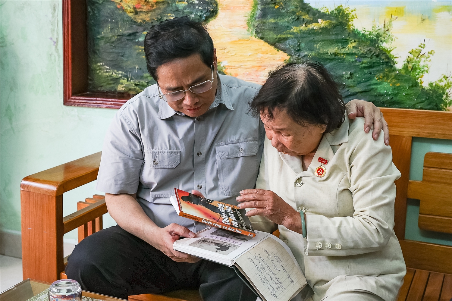 Thương binh Trần Thị Kim Cúc tặng Thủ tướng cuốn hồi ký "Chiến công và Đòn thù" của bà. Ảnh VGP/Nhật Bắc
