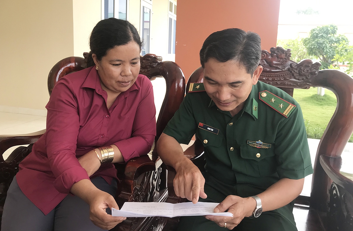 Chị Trần Kim Ly (bên trái) trao đổi với Trung tá Danh Tâm về việc vận động Nhân dân tham gia tự quản đường biên, mốc quốc giới
