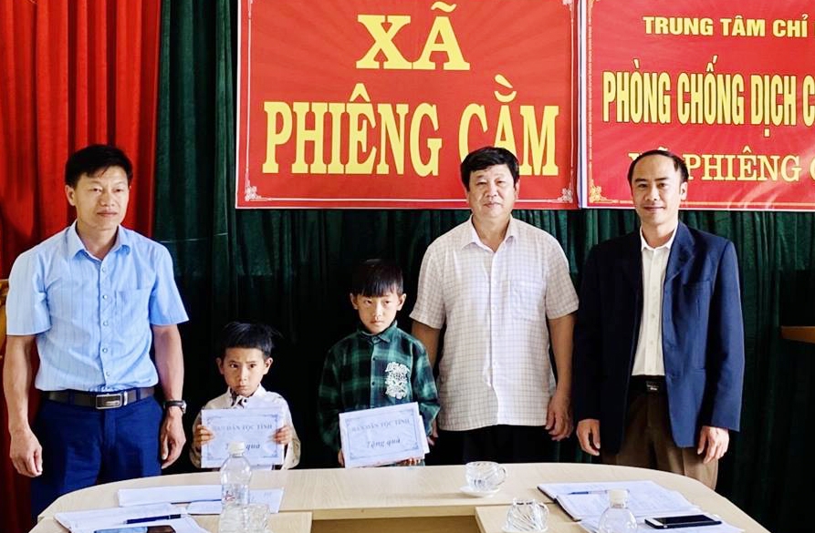 Ông Lường Văn Toán (thứ hai từ phải qua) tặng học bổng cho 2 học sinh có hoàn cảnh đặc biệt khó khăn ở xã Phiêng Cằm