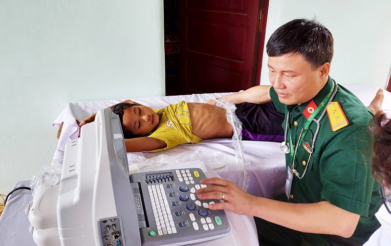 Bác sĩ, Trung tá Nguyễn Xuân Thành siêu âm cho bệnh nhi là người DTTS