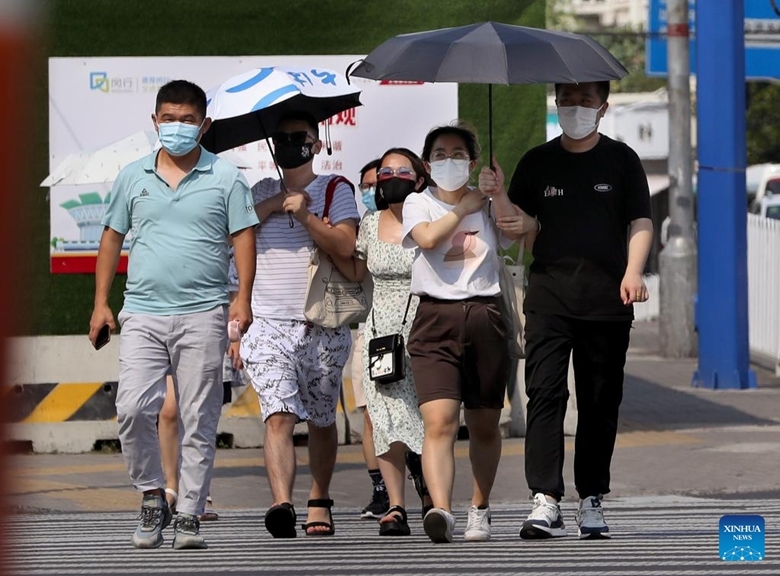 Người dân đeo khẩu trang khi đi lại trên một tuyến phố ở quận Mẫn Hàng, phía Đông thành phố Thượng Hải của Trung Quốc, ngày 10/7/2022. (Ảnh: Xinhua) 