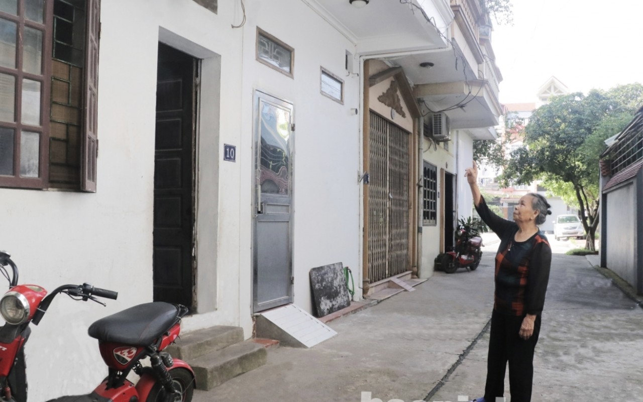 Bà Nguyễn Thị Bí bên căn nhà của mình vừa được Nhà nước hỗ trợ kinh phí sửa chữa 