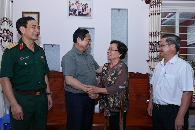 Thủ tướng Phạm Minh Chính thăm hỏi đời sống của thương binh Huỳnh Thị Kiển. Ảnh VGP/Nhật Bắc