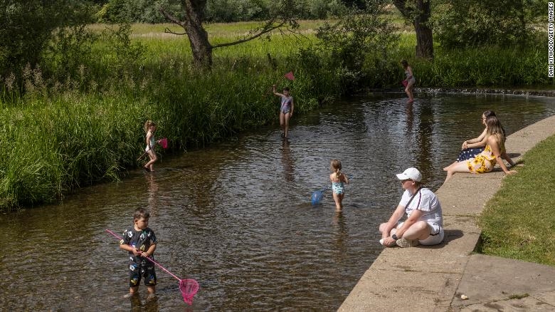 Các gia đình tắm mát ở sông Darent ở Eynsford, Anh. Ảnh: CNN