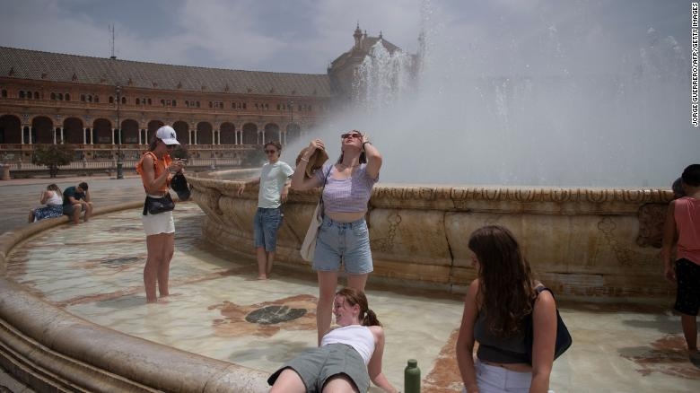 Người dân giải nhiệt ở đài phun trong đợt nắng nóng ở Seville, Tây Ban Nha. Ảnh: CNN