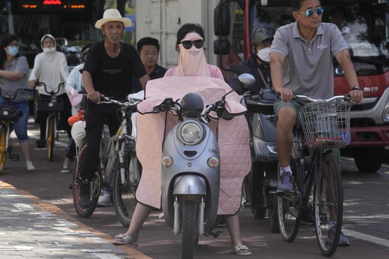Người phụ nữ bịt kín để che nắng tại Bắc Kinh. Ảnh AP