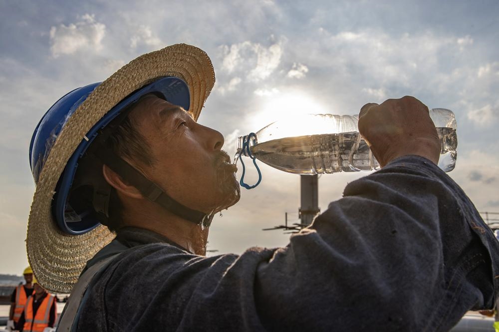 Công nhân uống nước giải khát tại công trường xây dựng ở Trùng Khánh, Tây Nam Trung Quốc. Ảnh: Tân Hoa xã