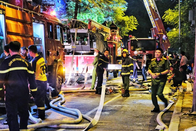 Cảnh sát nỗ lực dập lửa trong đám cháy ở phường Quan Hoa. (Ảnh: VGP/Minh Anh)