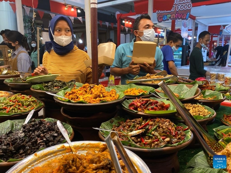 Những người bán hàng đeo khẩu trang khi chuẩn bị thức ăn phục vụ thực khách tại một cửa hàng ăn thuộc một trung tâm mua sắm ở Jakarta, Indonesia, ngày 7/8. (Ảnh: Xinhua)