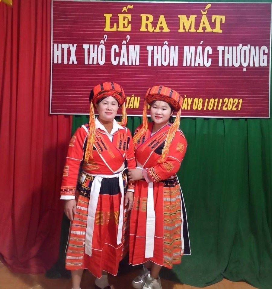 Nghệ nhân Ván Thị Chi (bên trái) chụp ảnh lưu niệm trong ngày Lễ ra mắt HTX thổ cẩm Pà Thẻn thôn Mác Thượng