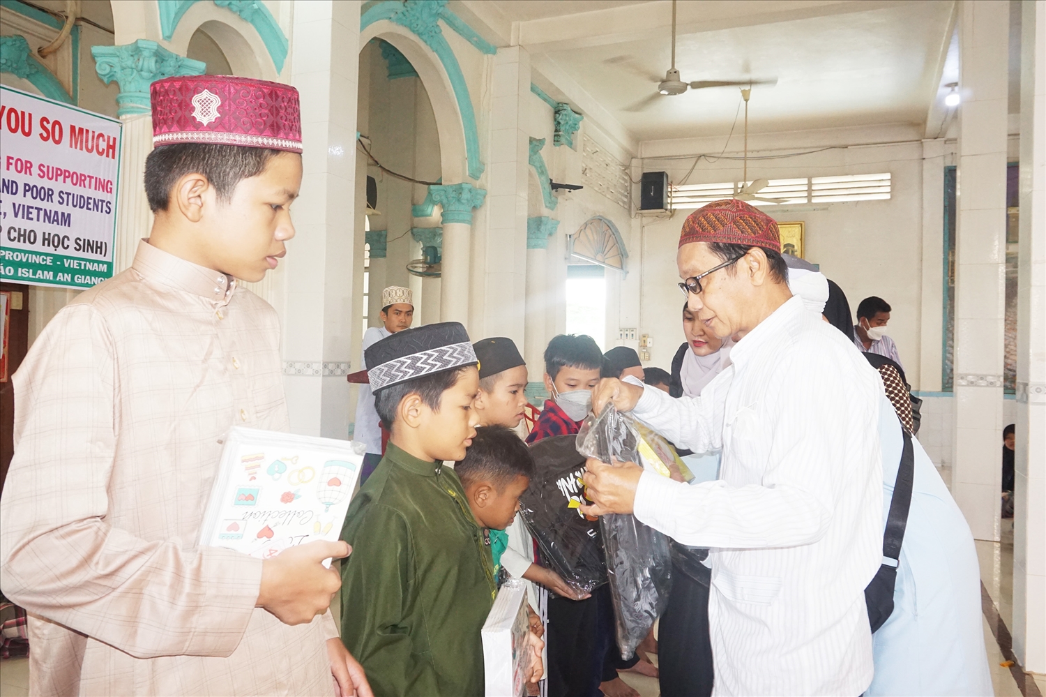 Ông Haji Jacky - Trưởng Ban Đại diện Cộng đồng Hồi giáo tỉnh An Giang trao quà cho các em học sinh có hoàn cảnh khó khăn
