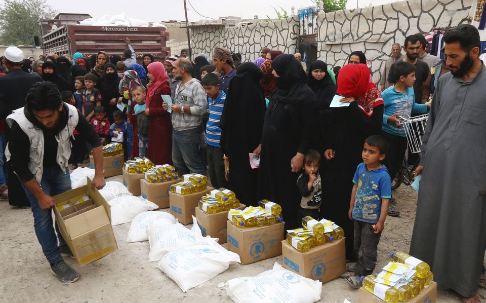 Người dân ở Raqqa, thuộc Syria xếp hàng dài chờ  nhận lương thực do Chương trình Lương thực Thế giới của Liên hiệp quốc cung cấp.