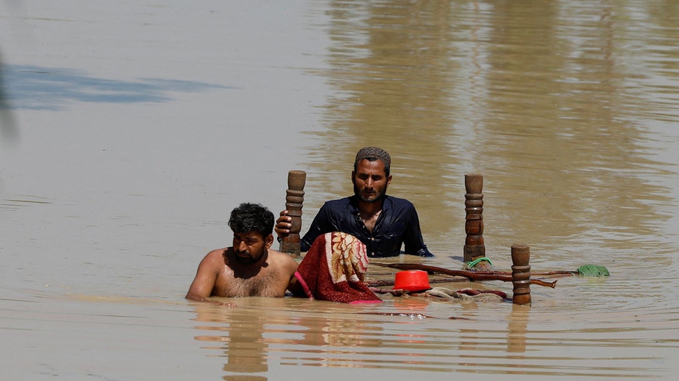 Người dân Charsadda lội nước lũ, mang theo đồ nội thất - Ảnh: SKY NEWS