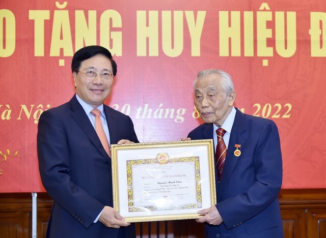 Thay mặt lãnh đạo Đảng, Chính phủ, đồng chí Phạm Bình Minh đã trao tặng Huy hiệu 75 năm tuổi Đảng cho đồng chí Nguyễn Mạnh Cầm - Ảnh: BNG