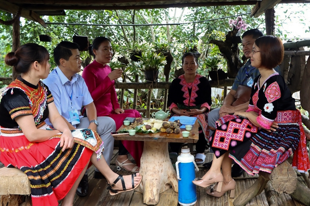 Đại biểu, du khách trò chuyện với người dân bản Lao Chải 1 và thưởng thức một số nông sản địa phương bên lề Hội thảo.