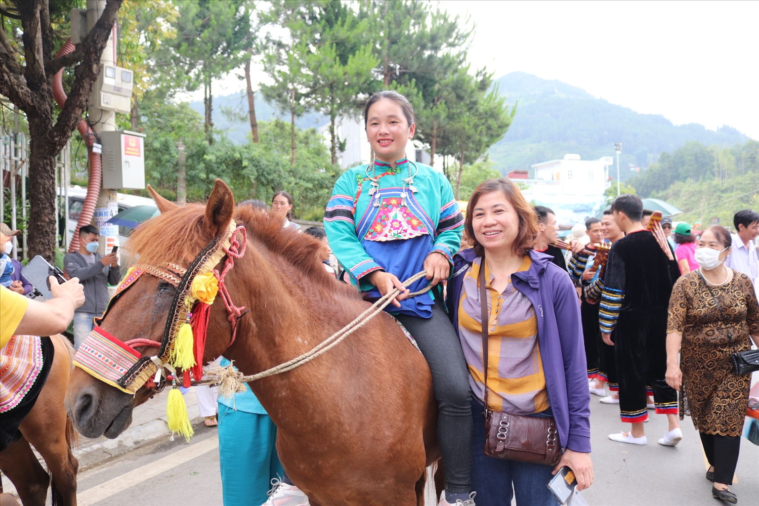 Du khách chụp ảnh cùng Cô gái Phù Lá cưỡi ngựa diễu hành trên phố 
