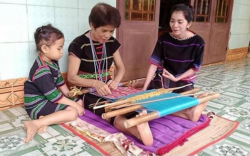Nghệ nhân Thị An Đê (xã Thọ Sơn, huyện Bù Đăng, Bình Phước) truyền nghề dệt thổ cẩm truyền thống cho con cháu. (Ảnh: Nhất Sơn)