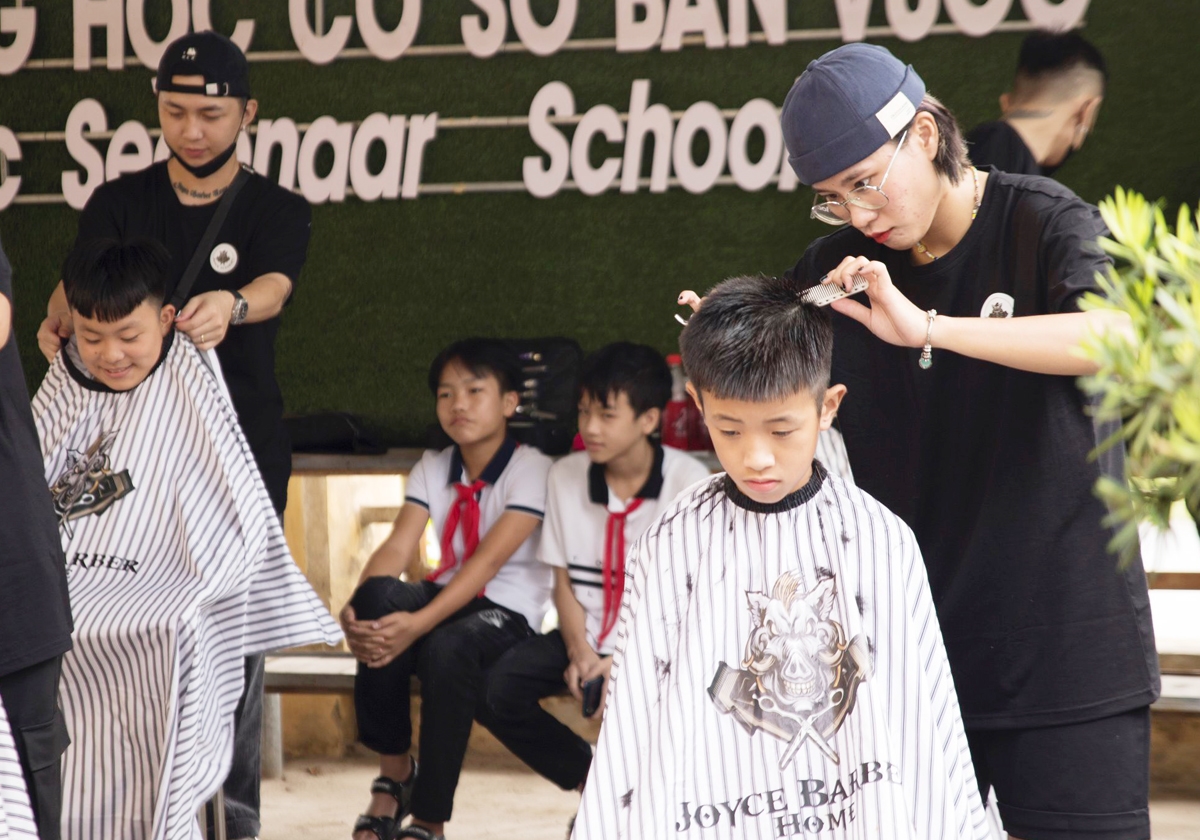 Các tình nguyện viên cắt tóc cho các em nhỏ tại Trường THCS Bản Vược