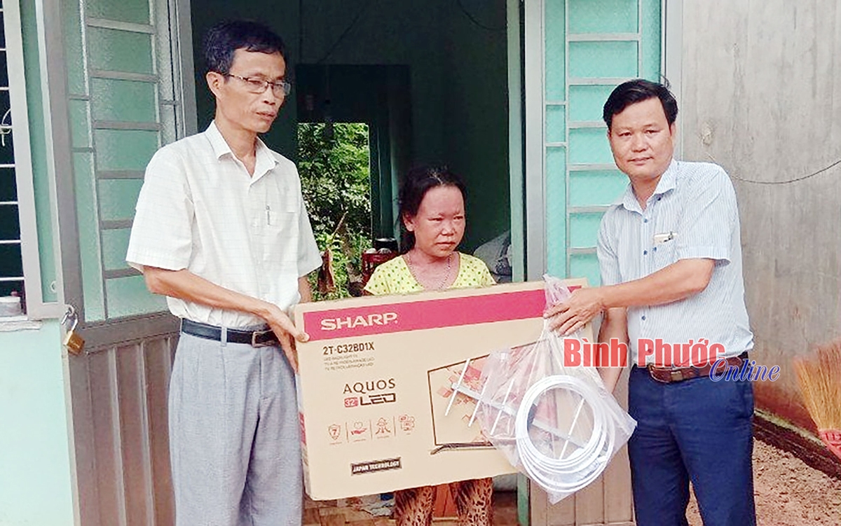 Đại diện UBND huyện Đồng Phú tặng tivi cho hộ bà Thị Tho, ấp Thuận Tiến, xã Thuận Lợi