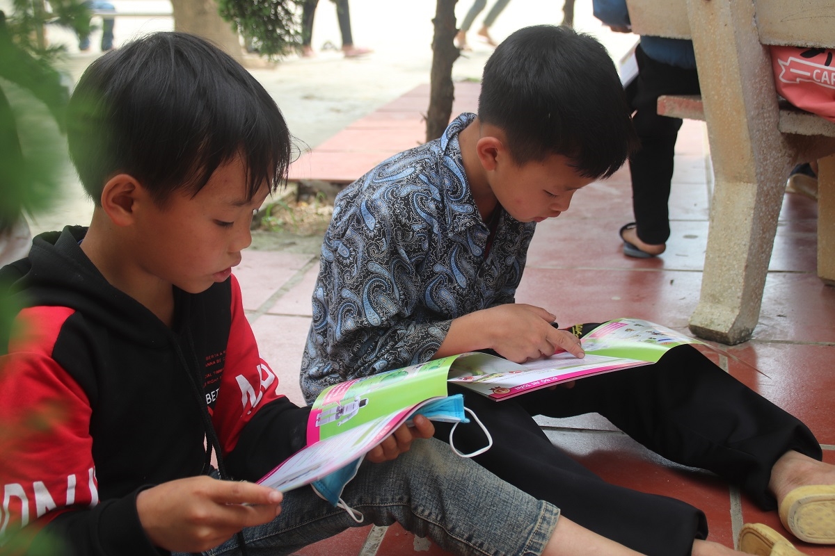 Những em học sinh ham đọc sách tại thư viện xanh ở một góc sân trường