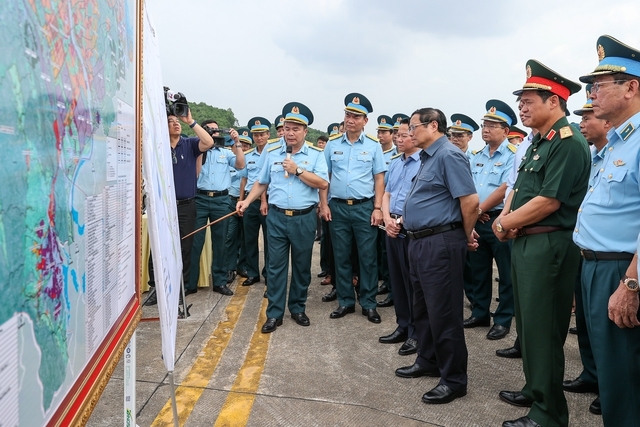 Thủ tướng nghe các đơn vị liên quan báo cáo khi khảo sát thực địa sân bay Yên Bái - Ảnh: VGP/Nhật Bắc