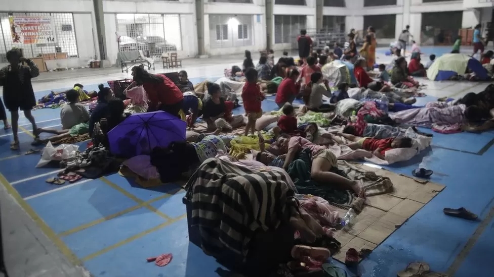 Những người sơ tán nghỉ ngơi bên trong một phòng tập thể dục được biến thành trung tâm sơ tán tạm thời ở Manila