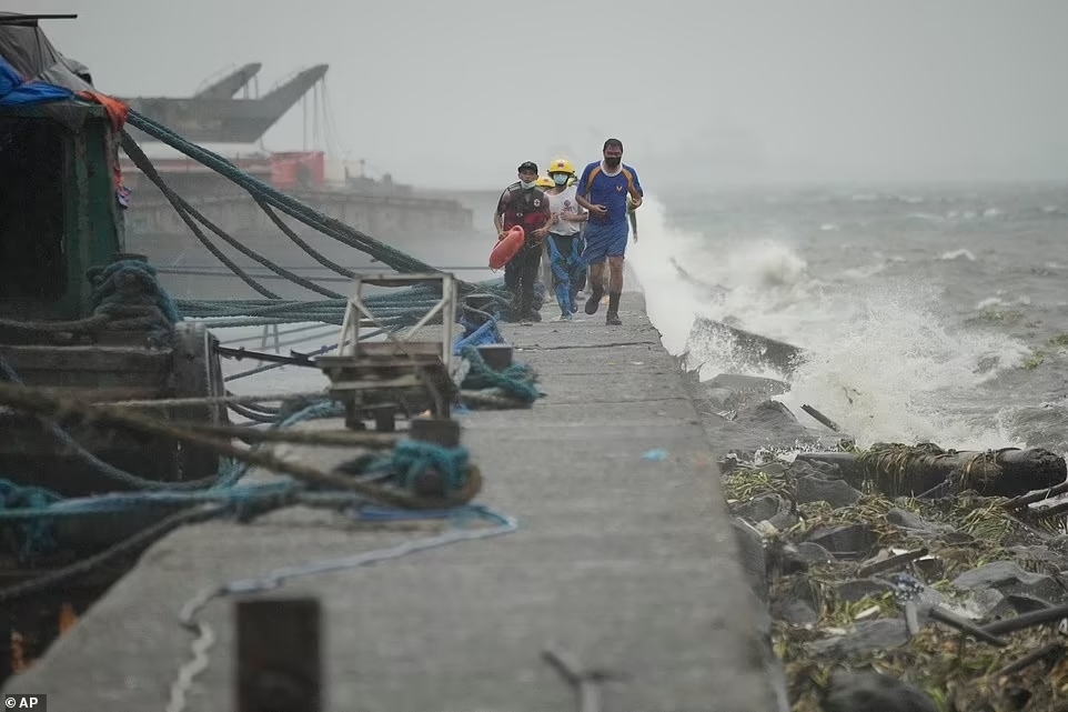 Lực lượng cứu hộ chạy khi họ kiểm tra các cư dân sống tại khu ổ chuột ven biển Tondo trong khi bão Noru tiếp cận Manila, thủ đô của Philippines, hôm nay