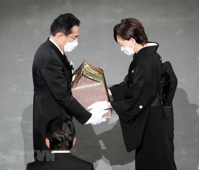Phu nhân cố Thủ tướng Nhật Bản Abe Shinzo, bà Abe Akie (phải) trao hũ tro cốt của chồng cho Thủ tướng Kishida Fumio trong Lễ Quốc tang tại Tokyo, ngày 27/9. (Ảnh: AFP/TTXVN)