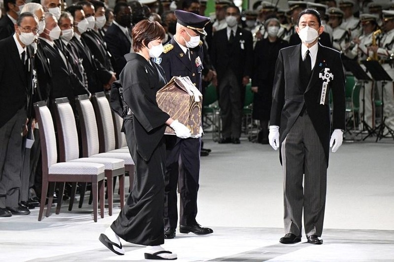 Phu nhân Akie Abe (giữa) mang tro cốt của cố Thủ tướng Nhật Bản Abe Shinzo vào hội trường Nippon Budokan (Tokyo), nơi diễn ra Lễ Quốc tang, ngày 27/9/2022. (Ảnh: AFP/TTXVN)
