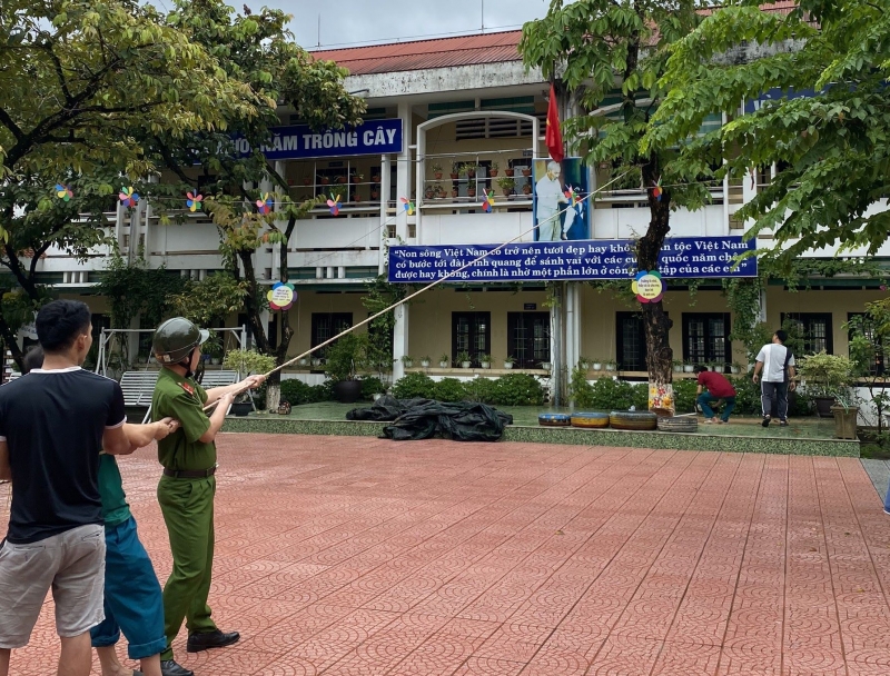 Công an phường Kim Long, TP Huế hỗ trợ cắt tỉa cành cây xanh tại trường học ở địa bàn phường trước bão số 4. Ảnh CAND