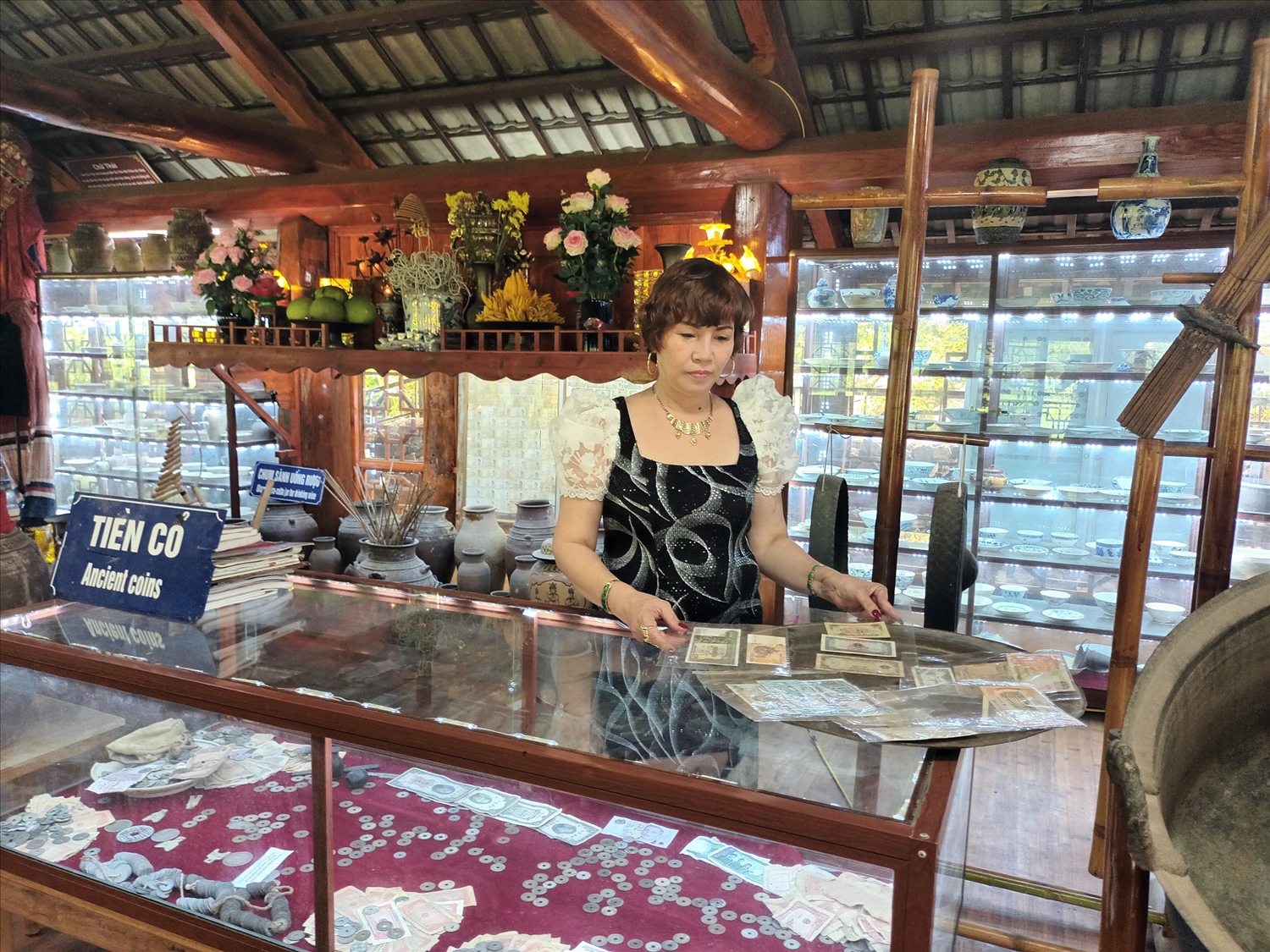 Chị Nguyễn Thị Tô Xuân bên bộ sưu tập tiền cổ tại Bảo tàng Thái Mai Châu