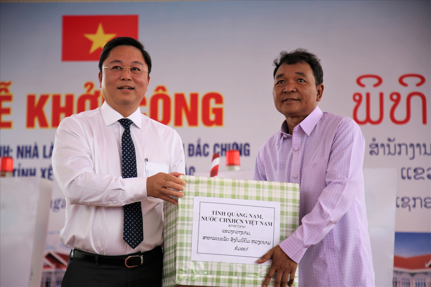 Chủ tịch UBND tỉnh Quảng Nam Lê Trí Thanh (bên trái) trao quà hỗ trợ cho đại diện lãnh đạo huyện Đắc Chưng (Sê Kông).
