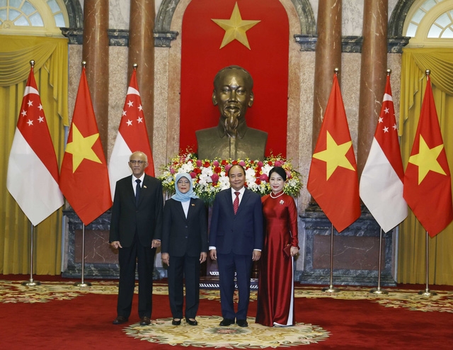 Nguyễn Xuân Phúc và Phu nhân cùng Tổng thống Cộng hòa Singapore Halimah Yacob và Phu quân tại lễ đón. Ảnh: TTXVN