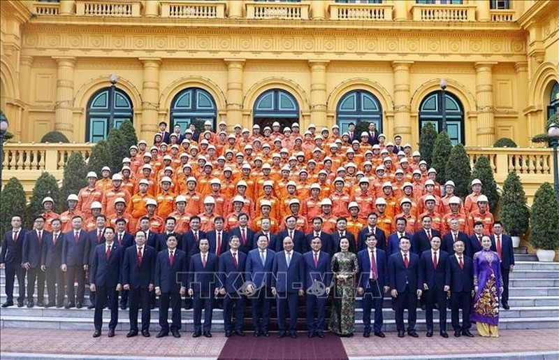 Chủ tịch nước Nguyễn Xuân Phúc cùng các thợ giỏi của Tập đoàn Điện lực Việt Nam (Ảnh: TTXVN)