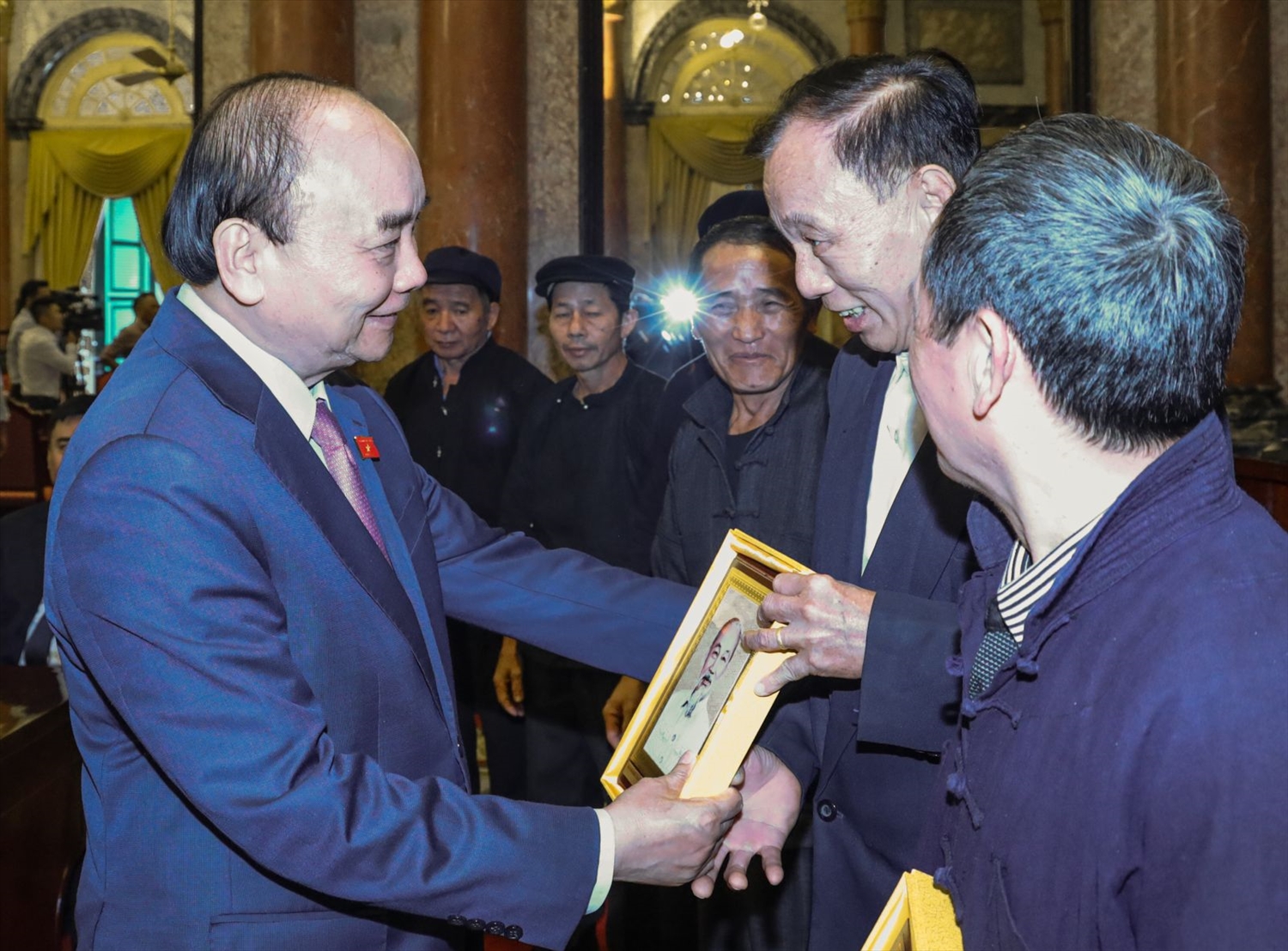 Chủ tịch nước Nguyễn Xuân Phúc tặng chân dung Bác Hồ cho các đại biểu người có uy tín tiêu biểu tỉnh Hà Giang. Ảnh: VPCTN