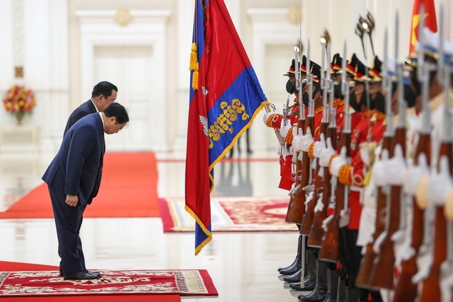 Hai Thủ tướng chào quân kỳ Quân đội hoàng gia Campuchia - Ảnh: VGP/Nhật Bắc
