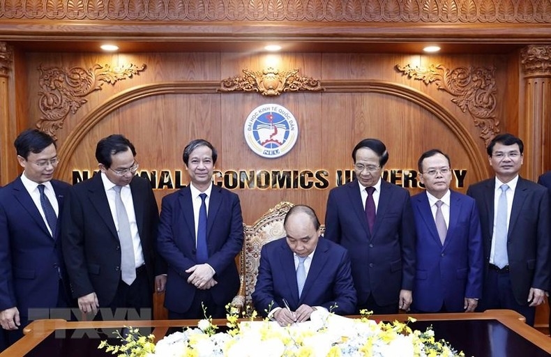 Chủ tịch nước Nguyễn Xuân Phúc viết lưu bút tại phòng truyền thống Trường đại học Kinh tế quốc dân. (Ảnh: Thống Nhất/TTXVN)
