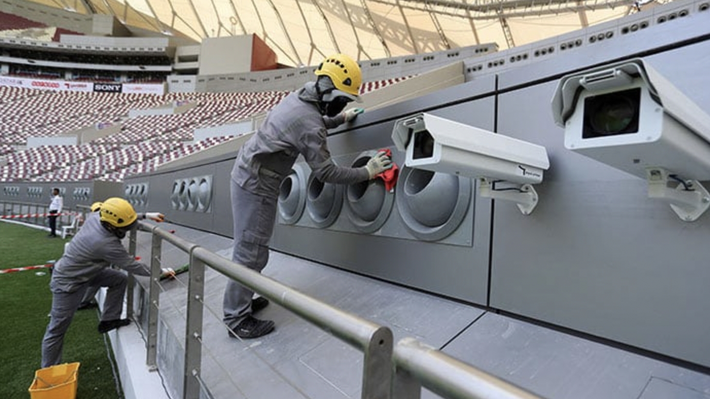 Công nhân thực hiện công tác lau chùi, bảo dưỡng hệ thống điều hoà không khí trên sân vận động của Qatar. Ảnh: AFP