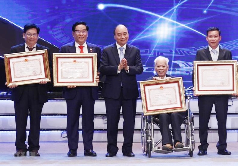 Chủ tịch nước Nguyễn Xuân Phúc trao Giải thưởng Hồ Chí Minh cho tác giả, đại diện tác giả, đại diện đồng tác giả của 12 công trình, cụm công trình được tặng Giải thưởng Hồ Chí Minh. (Ảnh: Thống Nhất/TTXVN)