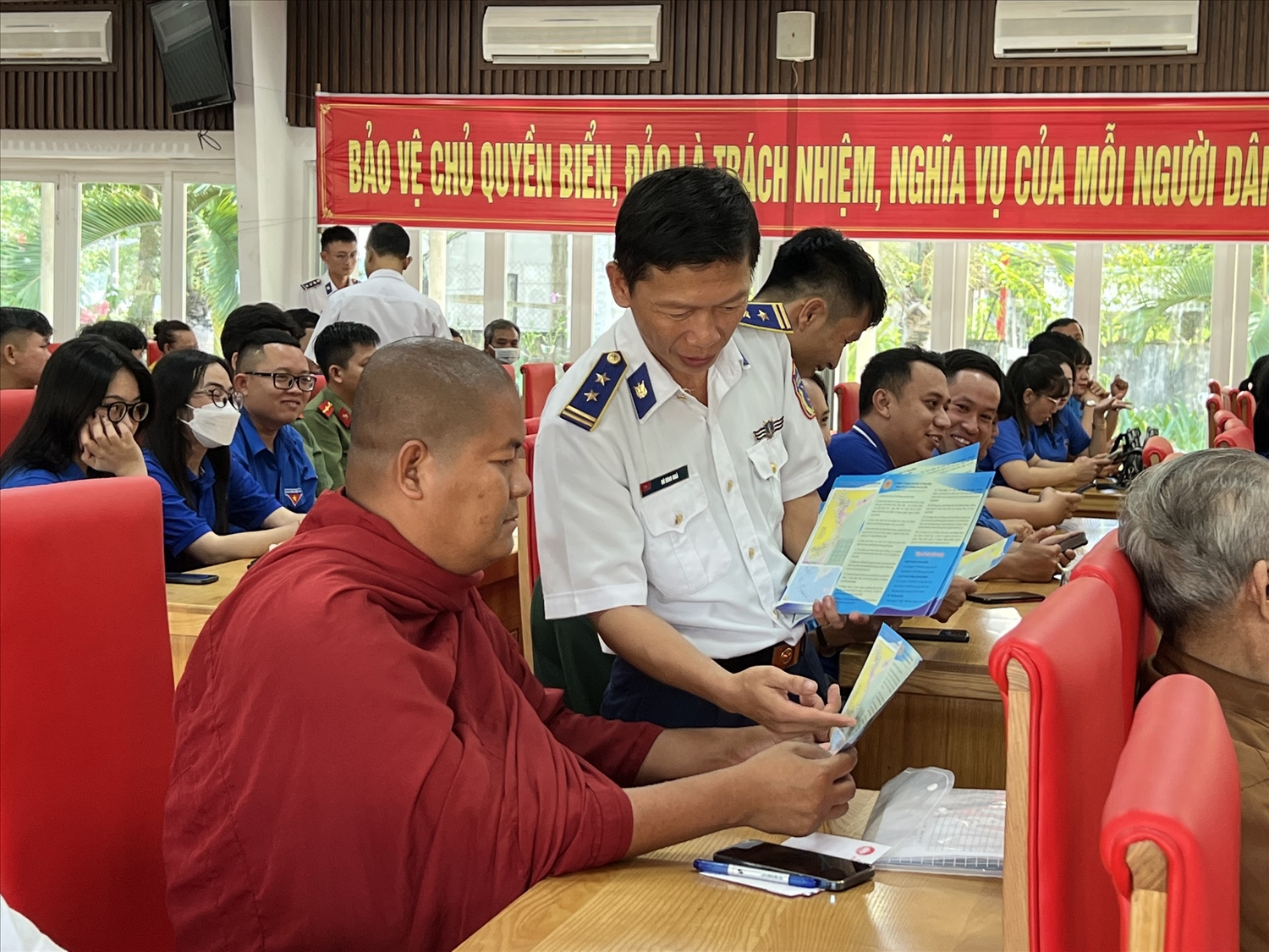 Trung tá Vũ Đình Ngà, Trưởng ban Tuyên huấn Vùng Cảnh sát biển 4 phát tờ rơi tuyên truyền cho chức sắc tôn giáo.