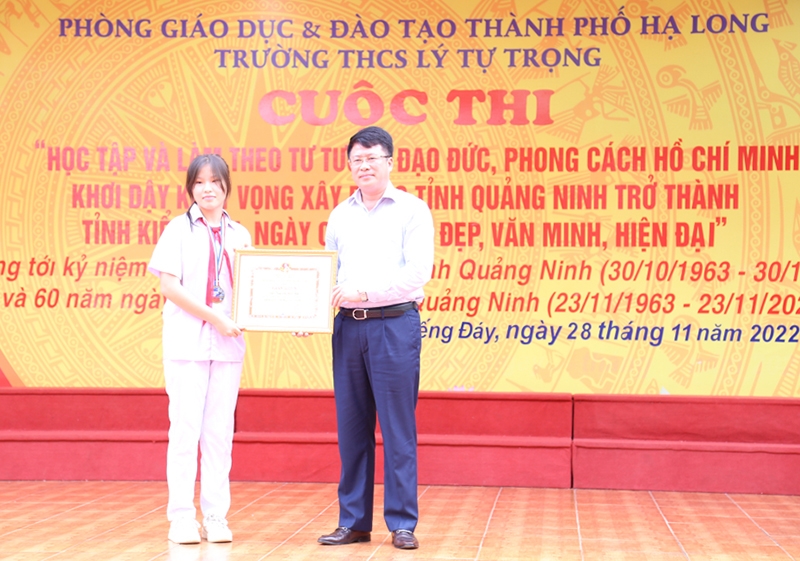 Ông Nguyễn Ngọc Sơn - Phó Chủ tịch UBND Tp. Hạ Long trao Giấy khen cho học sinh Trần Vũ Huệ Anh